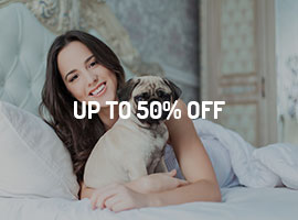 A woman laying on the bed with her dog.